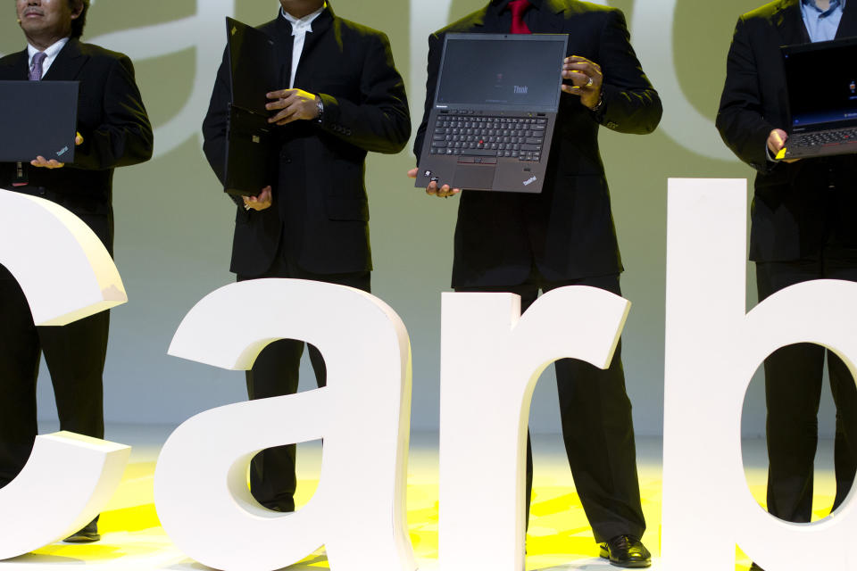 Lenovo executives hold the new ThinkPad X1 Carbon laptops in Beijing Monday, Aug. 6, 2012. The Chinese computer maker unveiled the lighter, quicker ThinkPad notebook computer inspired by the convenience of tablets and smart phones. (AP Photo/Alexander F. Yuan)