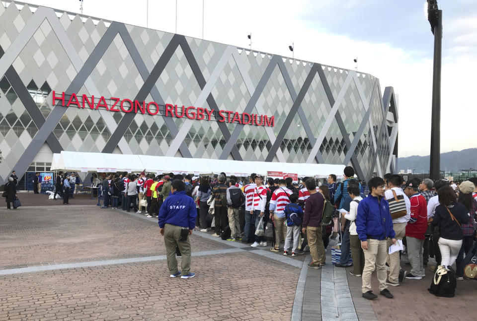In this Friday, Oct. 26, 2018, photo, fans line up to enter Hanazono Stadium in Higashiosaka, western Japan. The Stadium is one of 12 venues for the 2018 Rugby World Cup. The small town on the outskirts of Osaka is putting the finishing touches on its preparations to host the 2019 Rugby World Cup, the first time the sport's showcase event will be held in Asia. With a population just under 500,000, Higashiosaka is Japan's unofficial rugby Mecca. (AP Photo/Jim Armstrong)