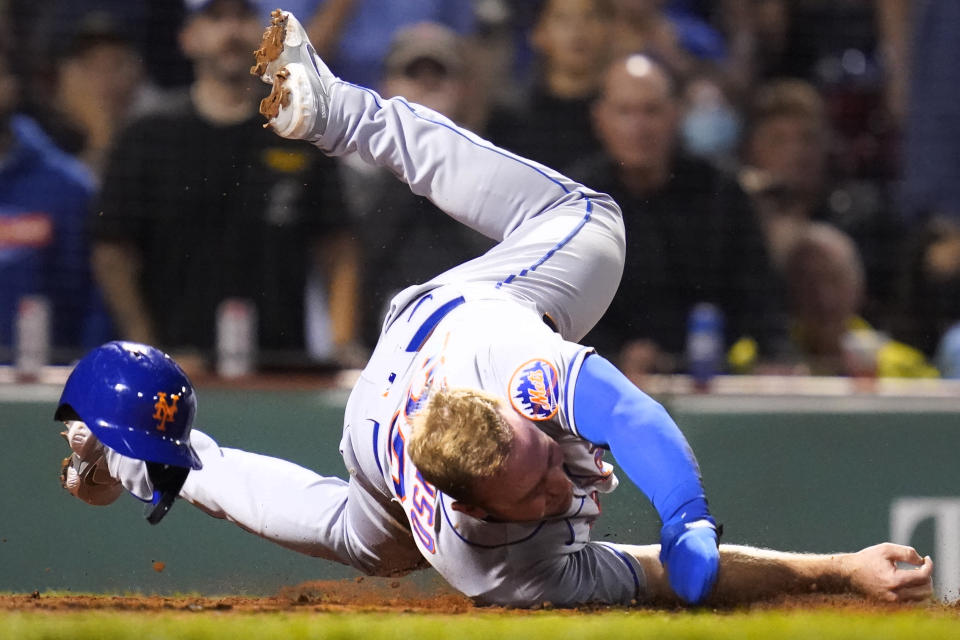 New York Mets' Pete Alonso rolls over home plate after being tagged out by Boston Red Sox catcher Christian Vazquez, while trying to score on a single by Michael Conforto, during the fourth inning of a baseball game at Fenway Park, Tuesday, Sept. 21, 2021, in Boston. (AP Photo/Charles Krupa)