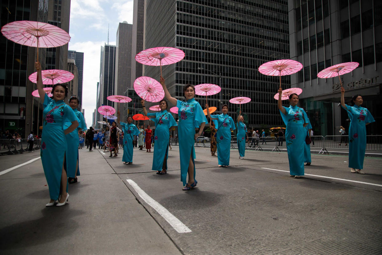 Woman dancing with pink umbrellas in the AAPI Parade. (Michael Nagle / Xinhua News Agency via Getty Images)