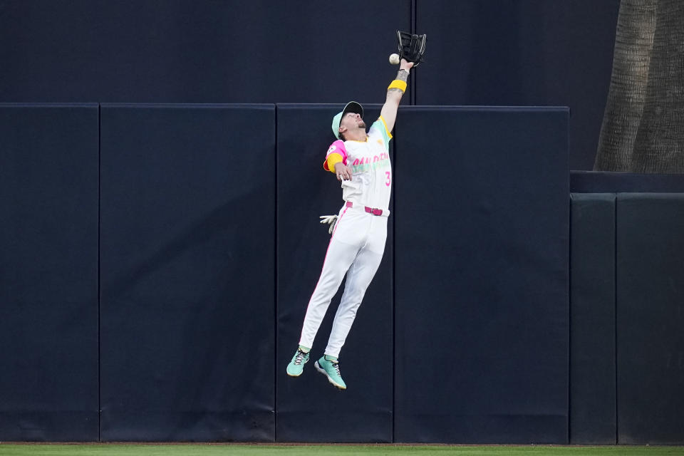 San Diego Padres center fielder Jackson Merrill cannot reach a home run hit by Toronto Blue Jays' Justin Turner during the first inning of a baseball game, Friday, April 19, 2024, in San Diego. (AP Photo/Gregory Bull)