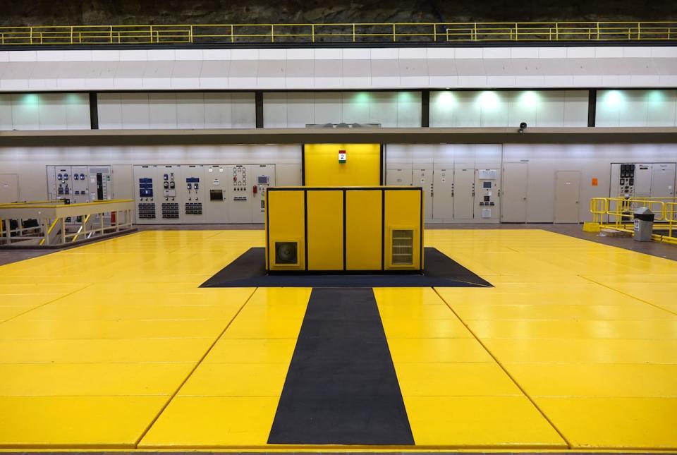 Below this yellow floor, one of the Churchill Falls plant's 11 generating units spins 200 times per minute. Each unit weighs 800 tonnes can be completely lifted out of the floor by two cranes.