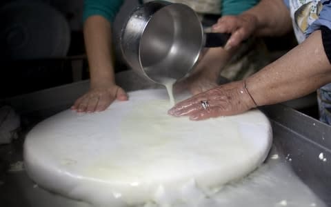 Women prepare traditional halloumi cheese at a house in the Cypriot village of Astromeritis, located some 30 km west of the capital Nicosia - Credit: AFP