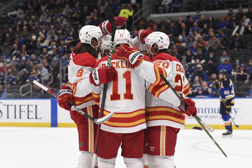 Calgary Flames center Mikael Backlund (11) is congratulated after scoring a goal against the St. Louis Blues during the first period of an NHL hockey game Thursday, Jan. 27, 2022, in St. Louis. (AP Photo/Joe Puetz)