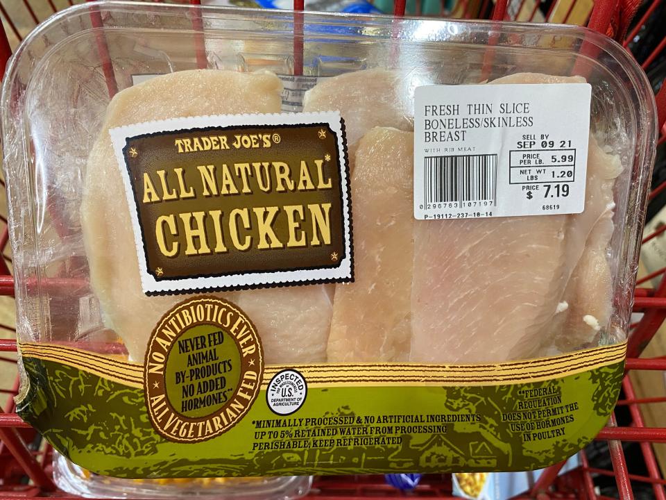 Trader Joe's thin sliced chicken in clear packaging in red cart