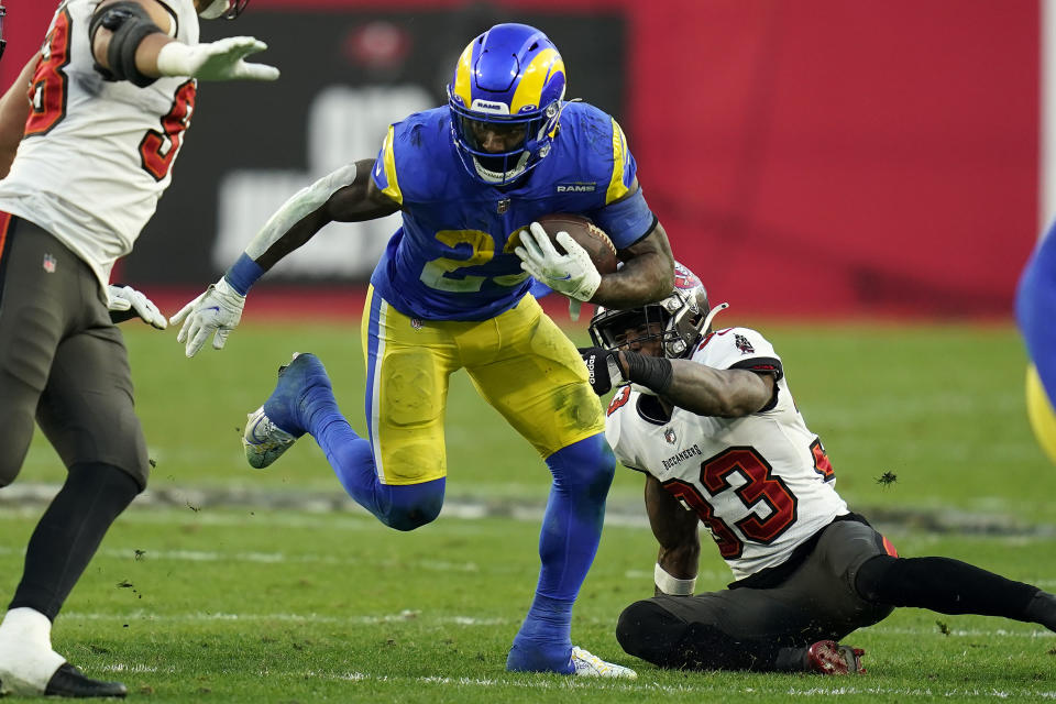 Los Angeles Rams running back Cam Akers (23) slips a tackle by Tampa Bay Buccaneers free safety Jordan Whitehead (33) during the second half of an NFL divisional round playoff football game Sunday, Jan. 23, 2022, in Tampa, Fla. (AP Photo/John Raoux)