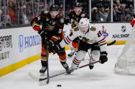 Anaheim Ducks defenseman Pavel Mintyukov, left, and Chicago Blackhawks right wing Joey Anderson vie for the puck during the second period of an NHL hockey game Thursday, March 21, 2024, in Anaheim, Calif. (AP Photo/Ryan Sun)