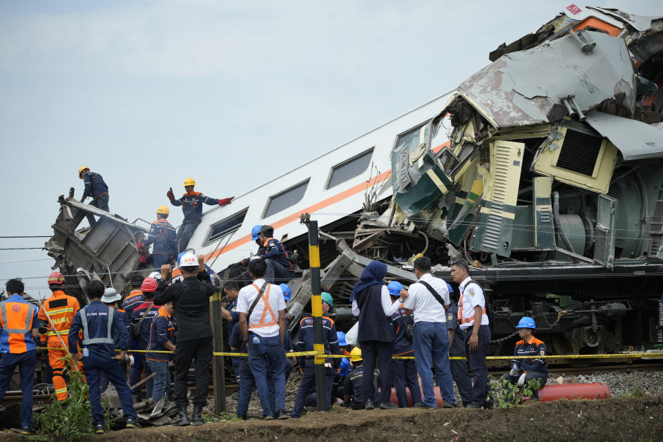 Rescuers inspect the wreckage after the collision between two trains in Cicalengka, West Java, Indonesia, Friday, Jan. 5, 2024. The trains collided on Indonesia's main island of Java on Friday, causing several carriages to buckle and overturn, officials said. (AP Photo/Achmad Ibrahim)