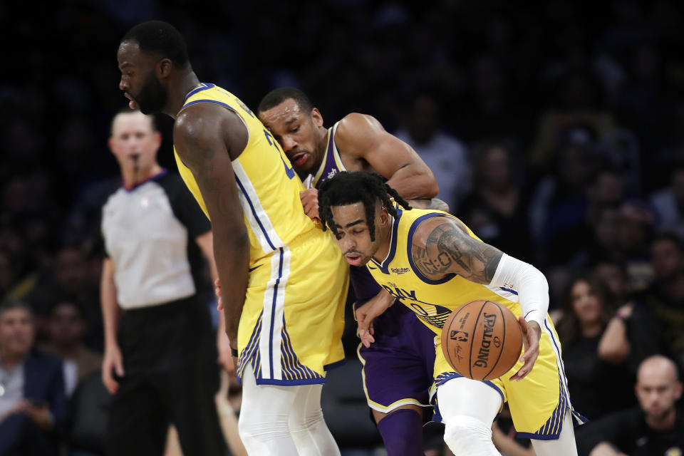 Golden State Warriors' D'Angelo Russell, right, dribbles around Los Angeles Lakers' Avery Bradley, center, on a screen from Draymond Green during the second half of an NBA basketball game Wednesday, Nov. 13, 2019, in Los Angeles. (AP Photo/Marcio Jose Sanchez)