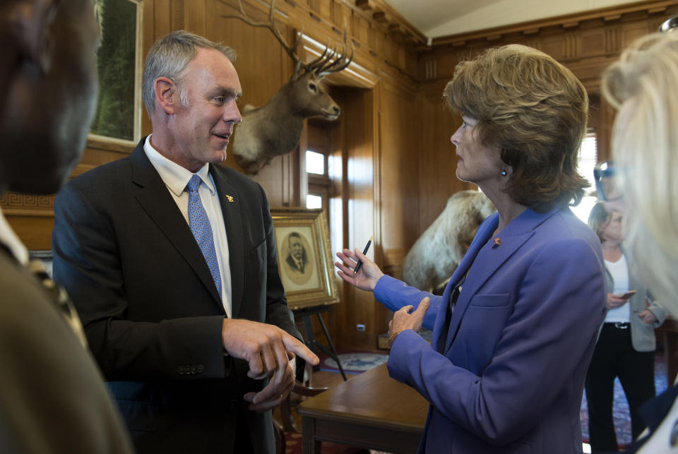 Interior Secretary Ryan Zinke speaks with Sen. Lisa Murkowski, R-Alaska at the Interior Department in Washington, Wednesday, March 29, 2017, after signing an order lifting a moratorium on new coal leases on federal lands and a related order on coal royalties. (AP Photo/Molly Riley)