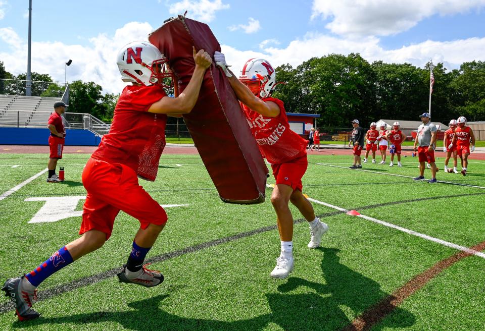 Natick High School football players (l-r) Cameron Bernard and Jack Showstead run drills during the first day of practice at Memorial Field, Friday, Aug. 8, 2023.