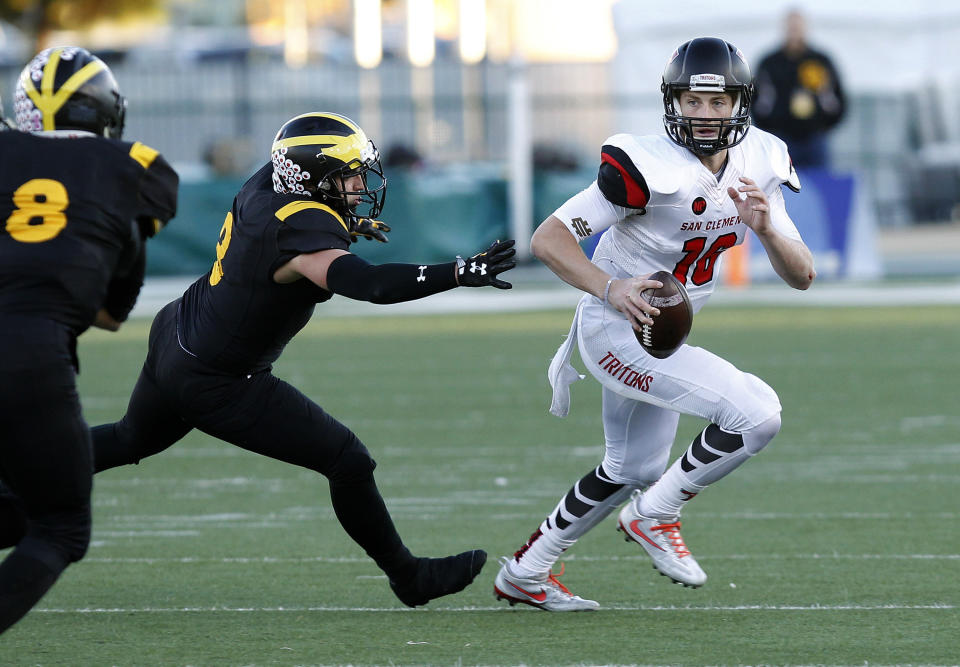 FILE - In this Dec. 17, 2016, file photo, San Clemente quarterback Jack Sears, right, eludes the grasp of Del Oro linebacker Andrew Birch, left, during the first half of the Division 1A high school football championship game in Sacramento, Calif. Sears replaced Sam Darnold at San Clemente High School. If Darnold’s first season as a starter at Southern California goes as well, Sears will get a chance to replace him again in 2018. (AP Photo/Steve Yeater, File)