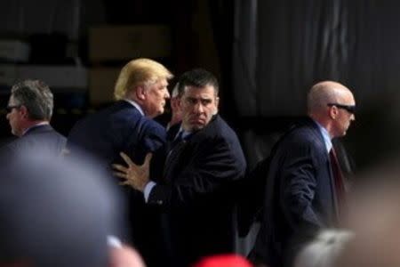 Secret Service agents surround Donald Trump during a disturbance as he speaks at Dayton International Airport in Dayton, Ohio March 12, 2016. REUTERS/Aaron P. Bernstein