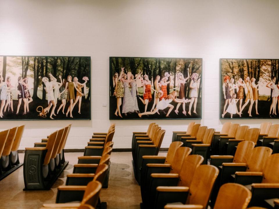 Rows of chairs in the auditorium, which is lined with paintings inspired by tarot cards.