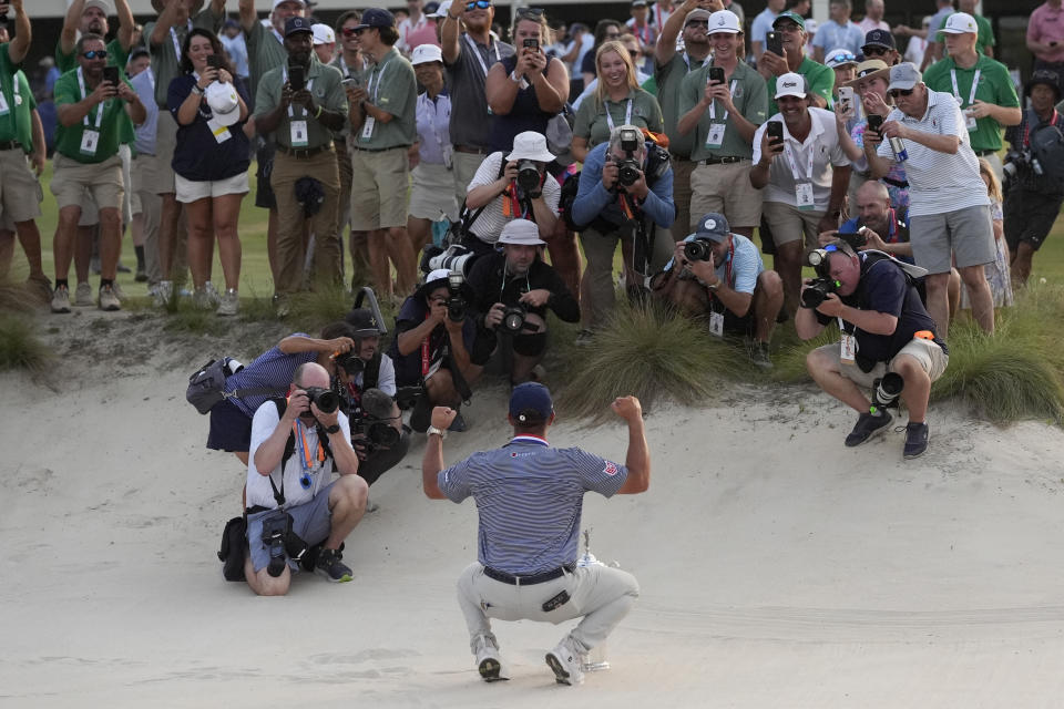 Bryson DeChambeau holds the trophy in the bunker after winning the U.S. Open golf tournament Sunday, June 16, 2024, in Pinehurst, N.C. (AP Photo/George Walker IV)