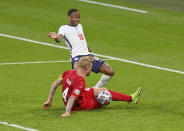 England's Raheem Sterling and Denmark's Simon Kjaer battle for the ball leading to an own goal from Kjaer during the Euro 2020 soccer championship semifinal between England and Denmark at Wembley stadium in London, Wednesday, July 7, 2021. (Justin Tallis/Pool Photo via AP)