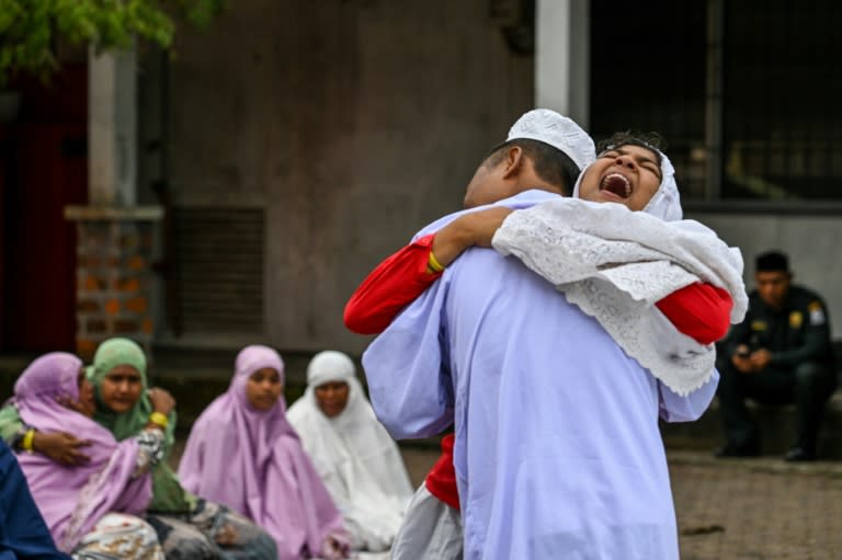 Des réfugiés rohingyas s'étreignent après avoir participé aux prières de l'Aïd al-Fitr dans un abri temporaire situé dans l'ouest de l'Indonésie, le 10 avril 2024 (CHAIDEER MAHYUDDIN)