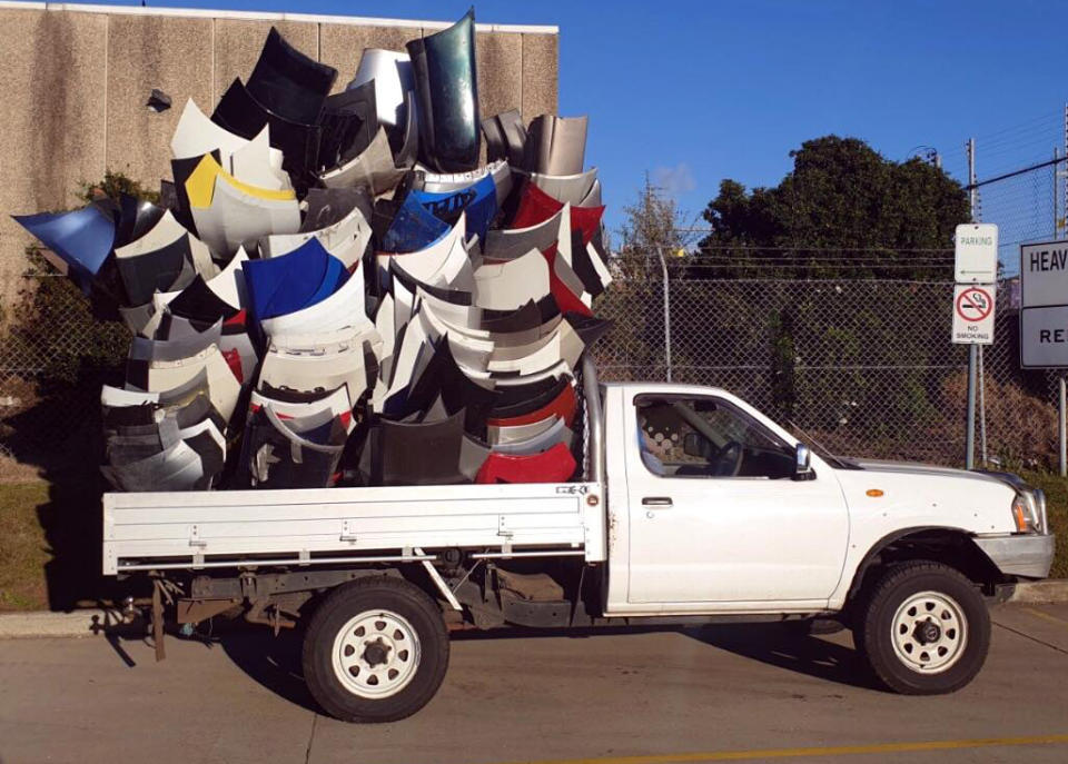A white ute piled high with bumpers in the tray.