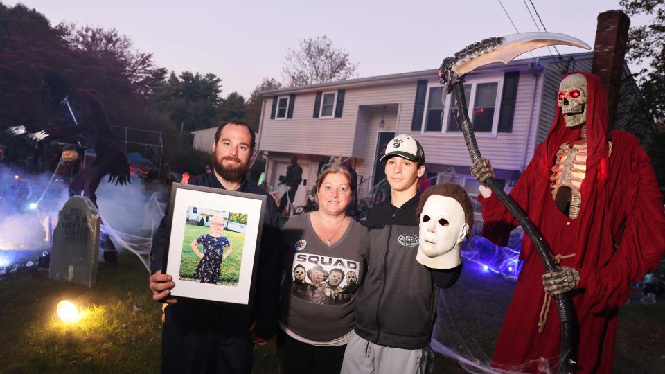 Evie Anderson of Raynham, 9, died of cardiac arrest on June 12, 2023. Her family went all-out decorating their yard for Halloween, Evie's favorite holiday, to honor and remember her. From left, Evie's parents Jared and Kimberly Anderson and her brother Cayden Anderson, 16, on Thursday, Oct, 12, 2023.