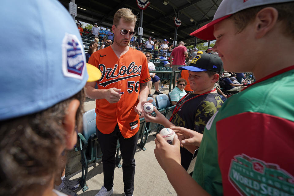 Baltimore Orioles' Kyle Bradish (56) gives autographs during a visit to the Little League World Series in South Williamsport, Pa., Sunday, Aug. 21, 2022. The Orioles play the Boston Red Sox in the Little League Classic on Sunday Night Baseball. (AP Photo/Gene J. Puskar)