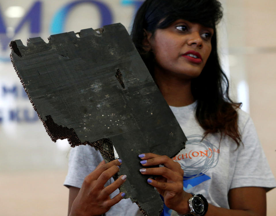 Grace Nathan, whose mother was onboard the missing Malaysia Airlines flight MH370, displays debris believed to belong to MH370 before handing over to Malaysia's Transport Minister Anthony Loke Siew Fook in Putrajaya, Malaysia November 30, 2018. REUTERS/Lai Seng Sin