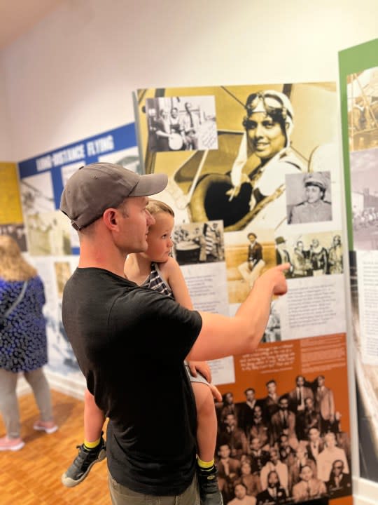 Father and child exploring the Smithsonian Institution Traveling Exhibition Black Wings American Dreams of Flight, Colorado Springs Pioneers Museum.