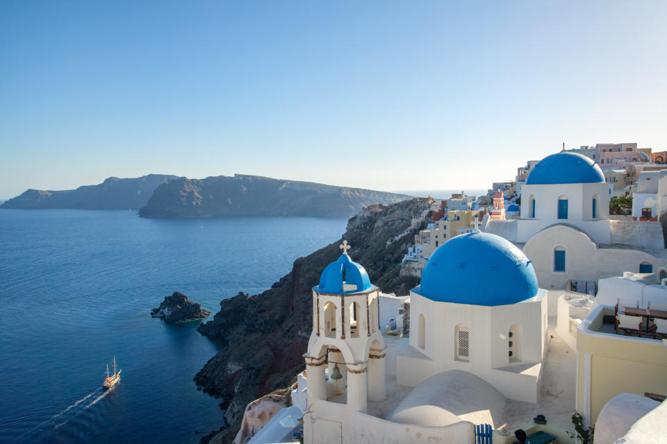 White buildings with blue rooftops overlooking the sea