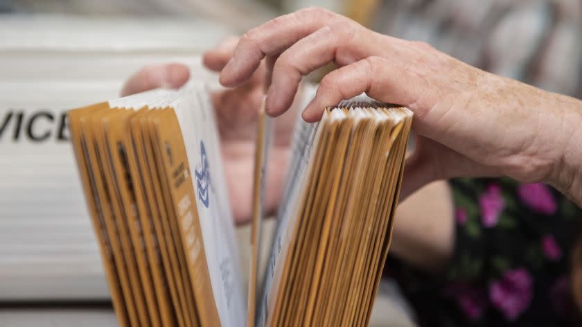 An employee of the Orange County Registrar of Voters sorts through mail-in ballots on Wednesday, Nov. 7, 2018 at their facility in Santa Ana. Many races in Orange County remain too close to call. (Nick Agro / For The Times)