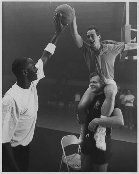Michael Jordan, Joe Pytka and Jim Riswold, on Pytka's shoulders, in a still from the filming of an early spot for Nike's Air Jordans, "Rockababy."