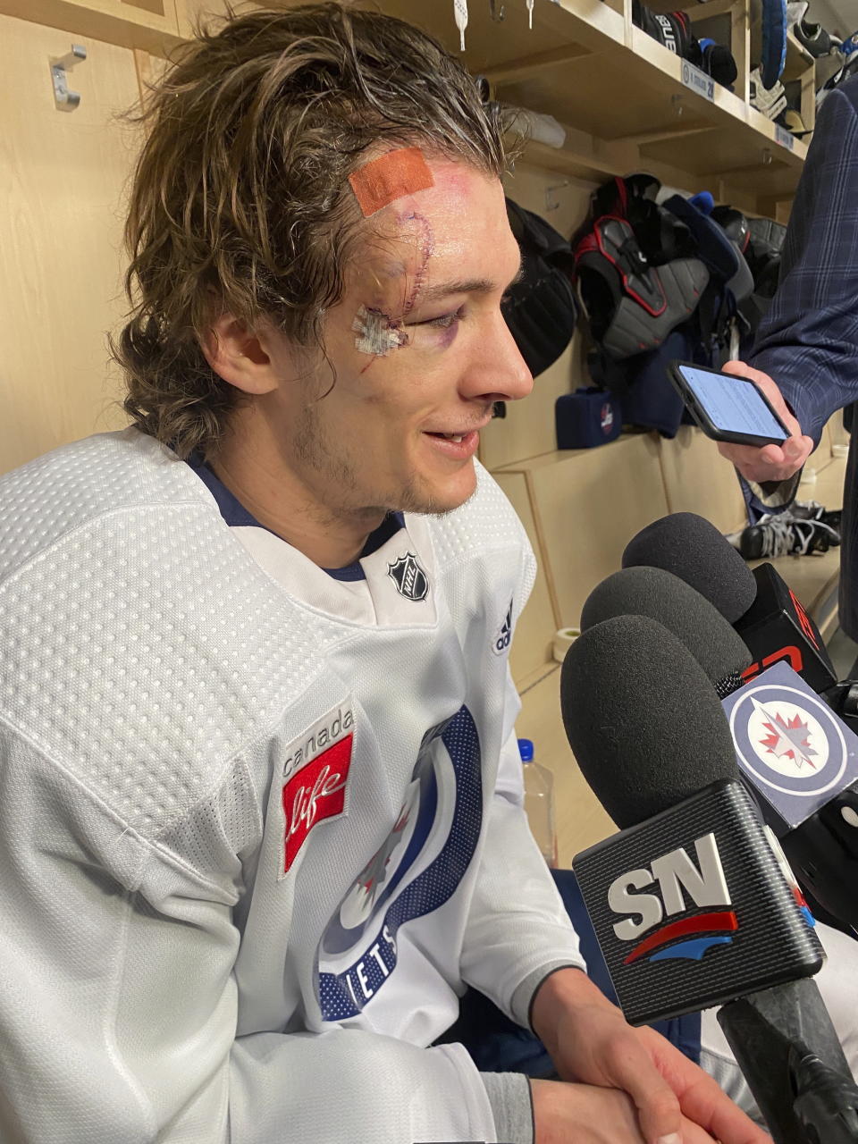 Winnipeg Jets center Morgan Barron speaks with reporters in the visitor's locker room at T-Mobile Arena in Las Vegas, Thursday, April 20, 2023. Barron said he will be able to play in Game 2 of their NHL round one playoff series against the Vegas Golden Knights despite taking a skate in the face in Game 1. (Gregory Strong/The Canadian Press via AP)