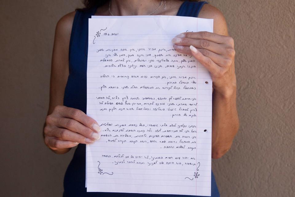 Idit Harel Segal, who donated a kidney to a Palestinian child from the Gaza Strip, holds with the letter she wrote to the boy, handwritten in Hebrew before giving him an Arabic translation, in her home in Eshhar, northern Israel