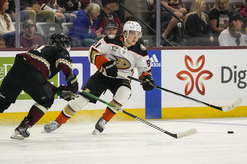 Anaheim Ducks' Leo Carlsson (91) chases the puck with Arizona Coyotes' Joust Valimaki, left, during the second period of an NHL hockey game Saturday, Oct. 21, 2023, in Tempe, Ariz. (AP Photo/Darryl Webb)