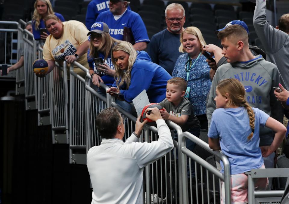 UK head coach John Calipari signed a basketball for Nolan Ryan Bertrand, 3, following practice ahead of their NCAA Tournament match up against Saint Peter's at the Gainbridge Fieldhouse in Indianapolis, In. on Mar. 16, 2022.