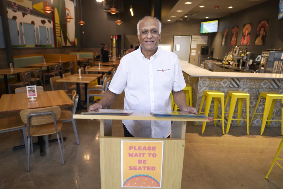 Mani Bhushan, owner of Taco Ocho, poses at one of his restaurants in McKinney, Texas, Friday, Nov. 11, 2022. Bhushan struggles to hire workers in the McKinney location, which opened in July 2021. He said many workers can't afford to live in this upscale suburb and have to travel from elsewhere. (AP Photo/LM Otero)