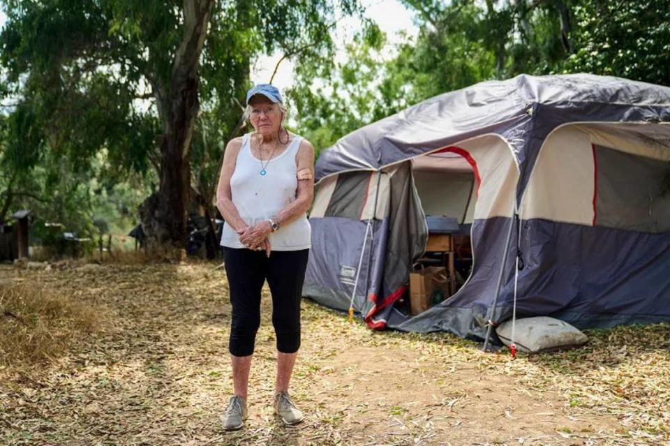 Katie Albert stands outside her tent in a homeless encampment behind City Hall in Ojai on June 13, 2023.