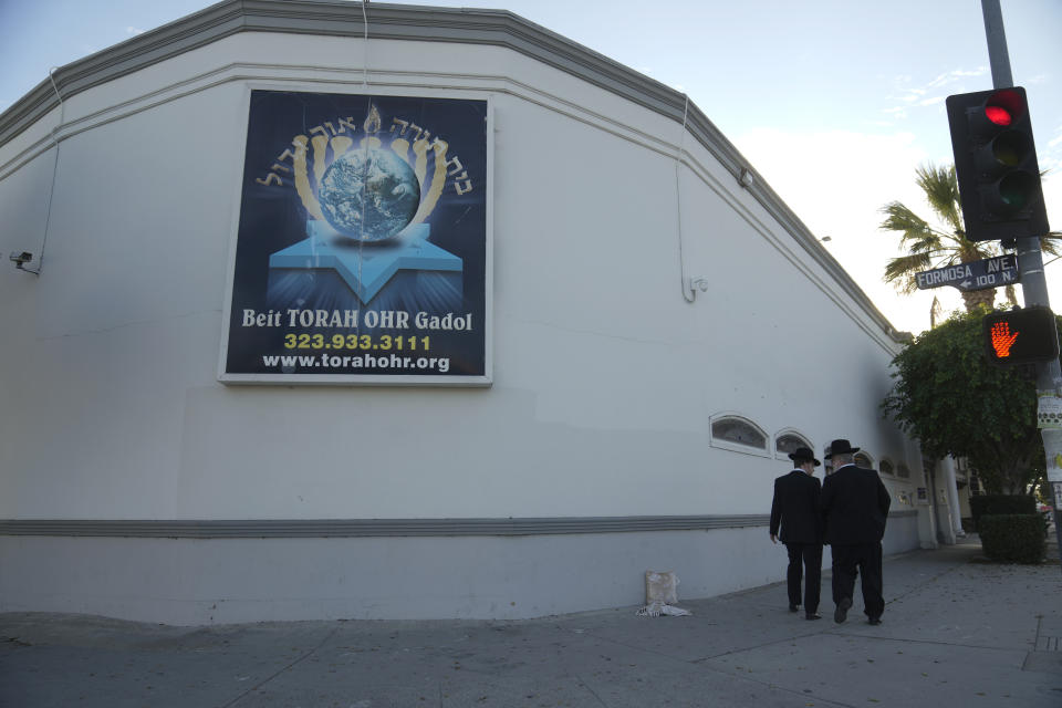 Men walk outside the Torah Ohr synagogue in Los Angeles on Saturday, Oct. 7, 2023. (AP Photo/Damian Dovarganes)