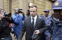 Oscar Pistorius is escorted outside court during a recess on the third day of his trial at the high court in Pretoria, South Africa, Wednesday, March 5, 2014, Pistorius is charged with murder for the shooting death of his girlfriend, Reeva Steenkamp, on Valentines Day in 2013. (AP Photo/Antoine de Ras) SOUTH AFRICA OUT