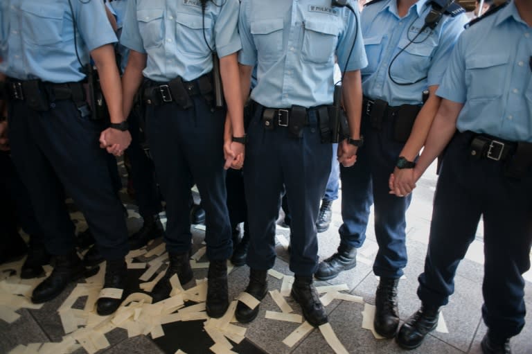 Paper money thrown at Hong Kong police lays scattered across their boots as they form a line to block protesters marching in Hong Kong on May 18, 2016