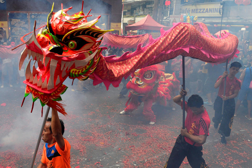 Revellers perform a dragon dance among smoke caused by firecrackers during Chinese Lunar New Year celebrations in Manila's Chinatown, Philippines January 28, 2017. (REUTERS/Ezra Acayan)