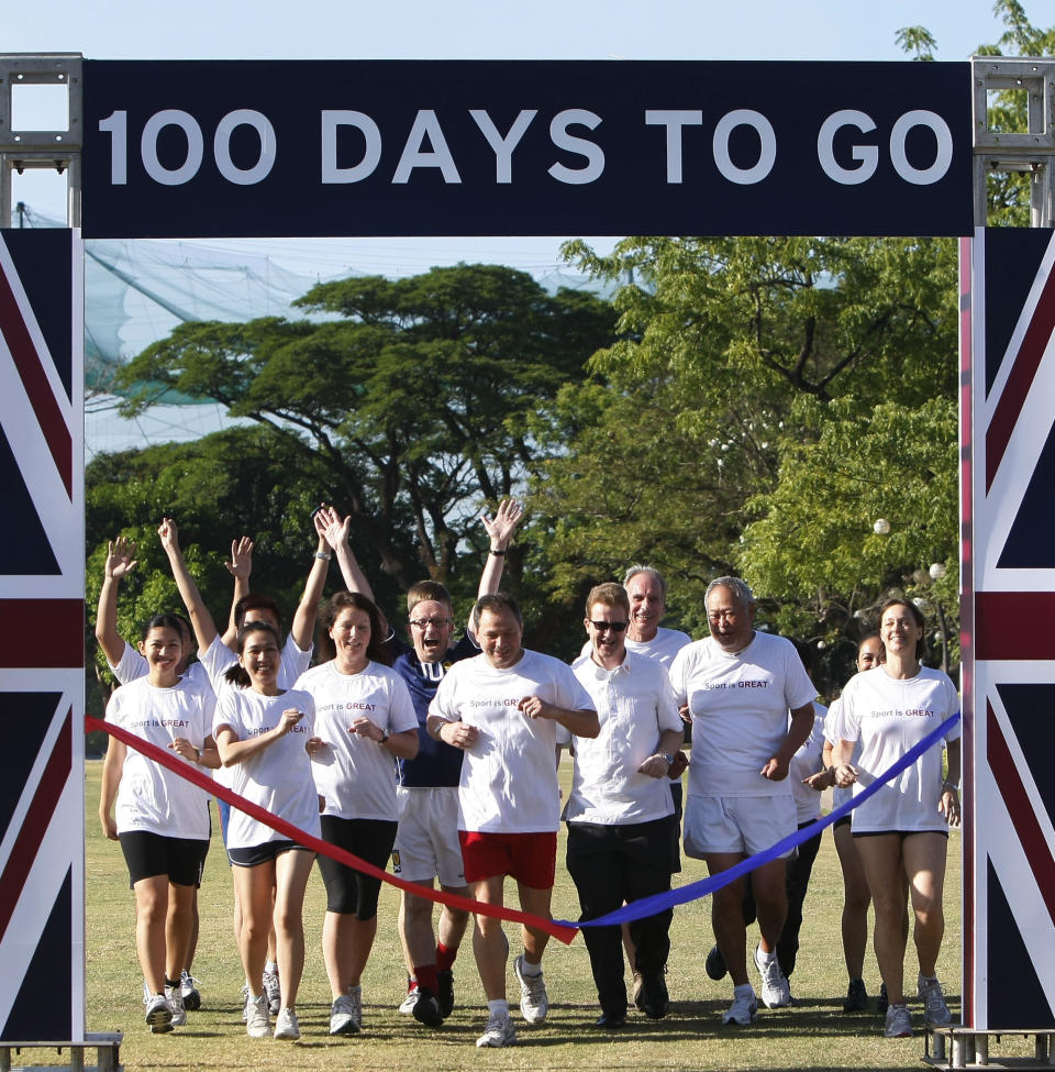 British and Filipino embassy staff, led by British Ambassador to the Philippines Stephen Lillie, third from right, front row, make the ceremonial 100m race to mark the 100 days countdown to the 2012 London Olympics Wednesday April 18, 2012 at the financial district of Makati city east of Manila, Philippines. Four Filipinos were chosen as Olympic torch bearers and six athletes were qualified for the Games. (AP Photo/Bullit Marquez)