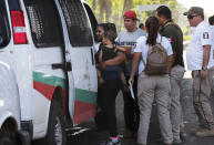 En esta imagen del 27 de mayo de 2019, una mujer migrante y su hijo son detenidos por agentes mexicanos de inmigración en Tapachula, en el estado de Chiapas, México. Washington ha exigido a México que detenga el flujo migratorio, en su mayoría de centroamericanos que huyen de la violencia y la pobreza, aunque también hay cubanos, haitianos y africanos. (AP Foto/Marco Ugarte)