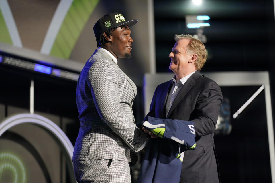 Mississippi State offensive lineman Charles Cross shakes hands with NFL Commissioner Roger Goodell after being chosen by the Seattle Seahawks with the ninth pick of the NFL football draft Thursday, April 28, 2022, in Las Vegas. (AP Photo/John Locher )