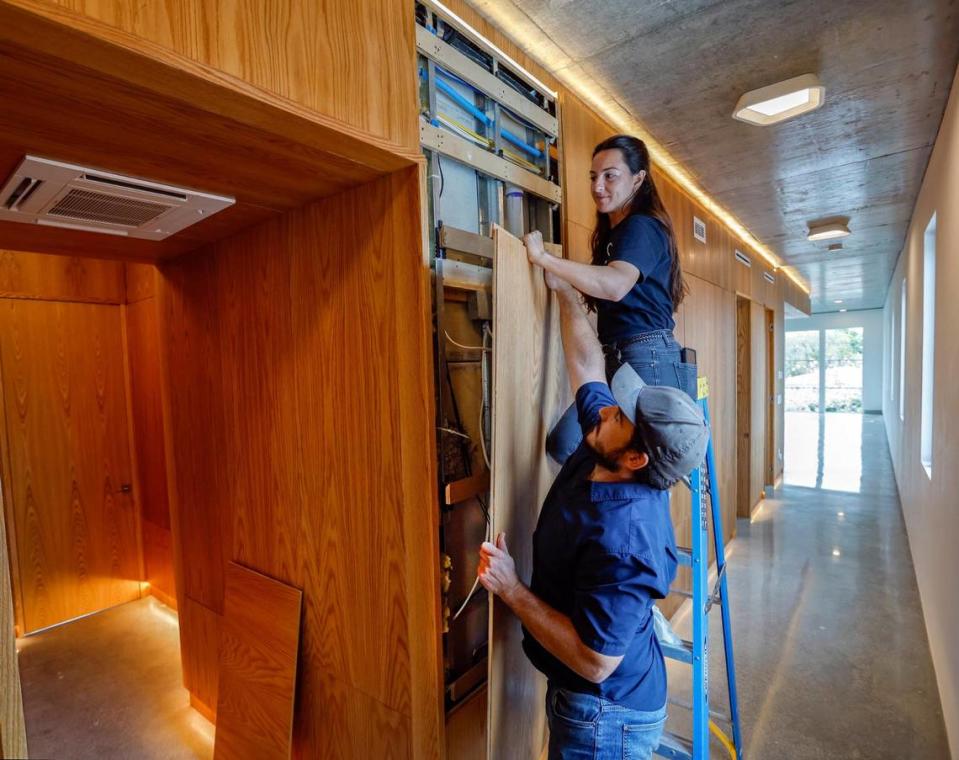 Katie Flood, asociada de diseño y el jefe de obra Pedro Alberni, retiran un panel interior para acceder a los sistemas eléctricos ocultos, el jueves 4 de abril de 2024. La casa recién construida en el barrio miamense de Silver Bluff obtuvo uno de los más altos honores en diseño arquitectónico. Es la primera del mundo en obtener la certificación del Well Building Institute.