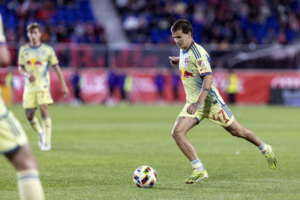 New York Red Bulls defender John Tolkin, right, passes the ball during an MLS soccer match against the Vancouver Whitecaps, Saturday, April 27, 2024, in Harrison, N.J. (AP Photo/Stefan Jeremiah)