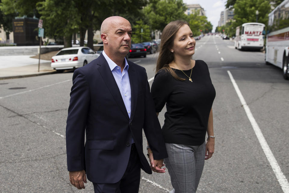 In this June 24, 2019, photo, Former Venezuelan police commissioner Ivan Simonovis walks across the street as he poses for a photograph with his wife Bony Pertnez, in Washington. In his first interview from exile in the U.S., Simonovis, the former police commissioner whose about 15-year detention became an opposition rallying cry, shares details of his movie-like breakout. (AP Photo/Alex Brandon)