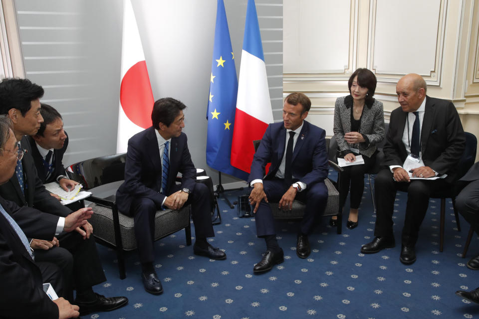 French President Emmanuel Macron attends a bilateral meeting with Japan's Prime Minister Shinzo Abe and French Foreign Minister Jean-Yves le Drian, right, at the G7 summit in Biarritz, southwestern France, Saturday, Aug. 24, 2019. Shadowed by the threat of global recession, a U.S. trade war with China and the possibility of one against Europe, the posturing by leaders of the G-7 rich democracies began well before they stood together for a summit photo. (Philippe Wojazer/Pool via AP)