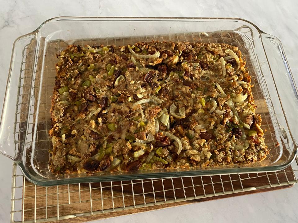 Sunny Anderson's stuffing cooked in a glass baking dish on white counter