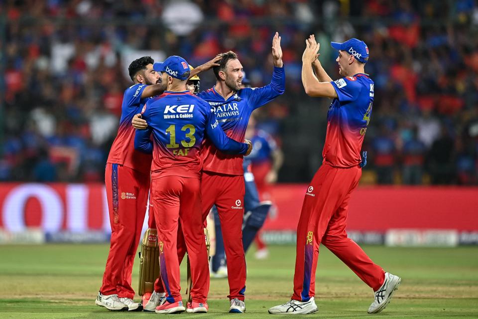 Royal Challengers Bengaluru's Glenn Maxwell celebrates with teammates after taking the wicket of Lucknow Super Giants' captain KL Rahul during the cricket match between RCB and LSG at the M Chinnaswamy Stadium in Bengaluru on April 2, 2024.