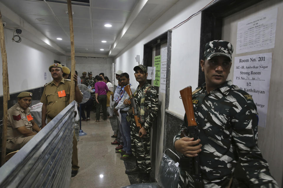 Indian paramilitary force soldiers stand guard outside a room where voting machines are stored as counting votes of India's massive general elections begins in New Delhi, India, Thursday, May 23, 2019. The count is expected to conclude by the evening, with strong trends visible by midday. (AP Photo/Manish Swarup)