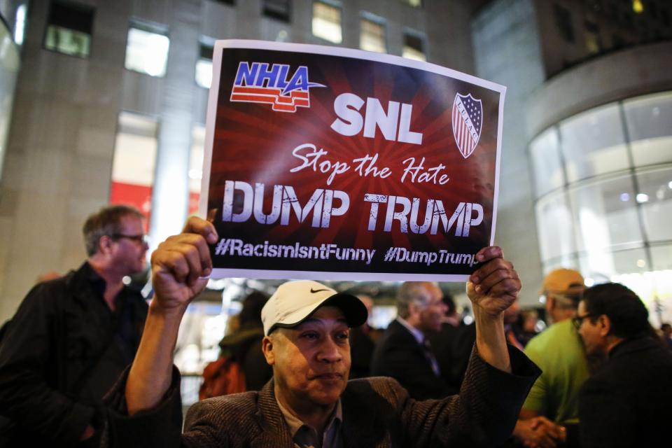 A man protests in  front of NBC studios while other call calling for the network to rescind the invitation to Donald Trump to host Saturday Night Live show on November 4, 2015 in New York. 